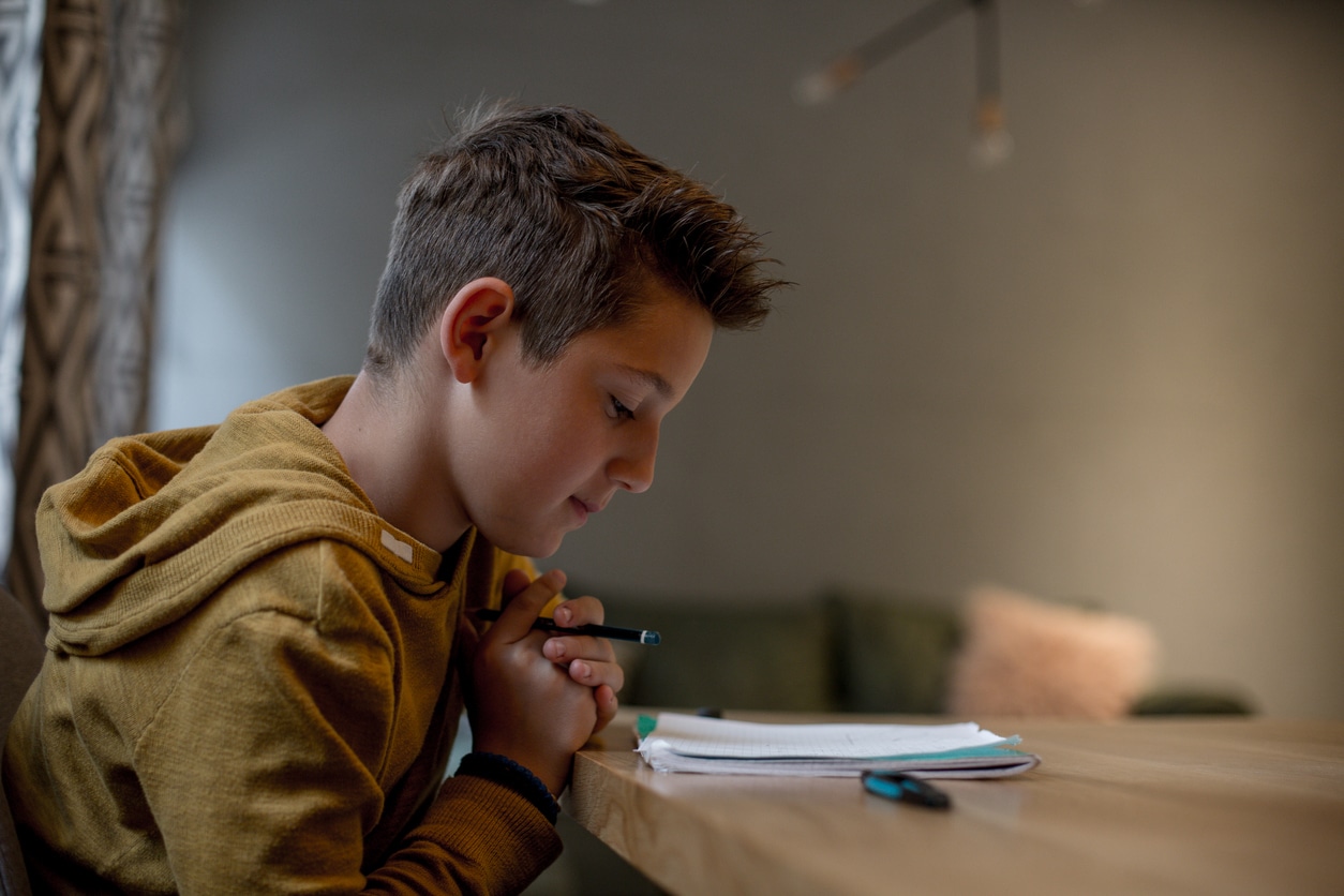 enfant collégien en train de travailler faire ses devoirs réviser pour le brevet