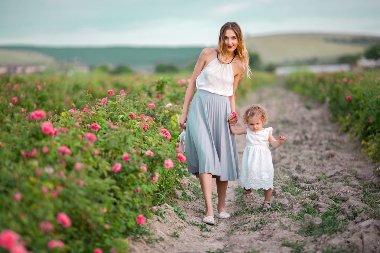 femme mère et enfant promenade dans un jardin de printemps avec des fleurs